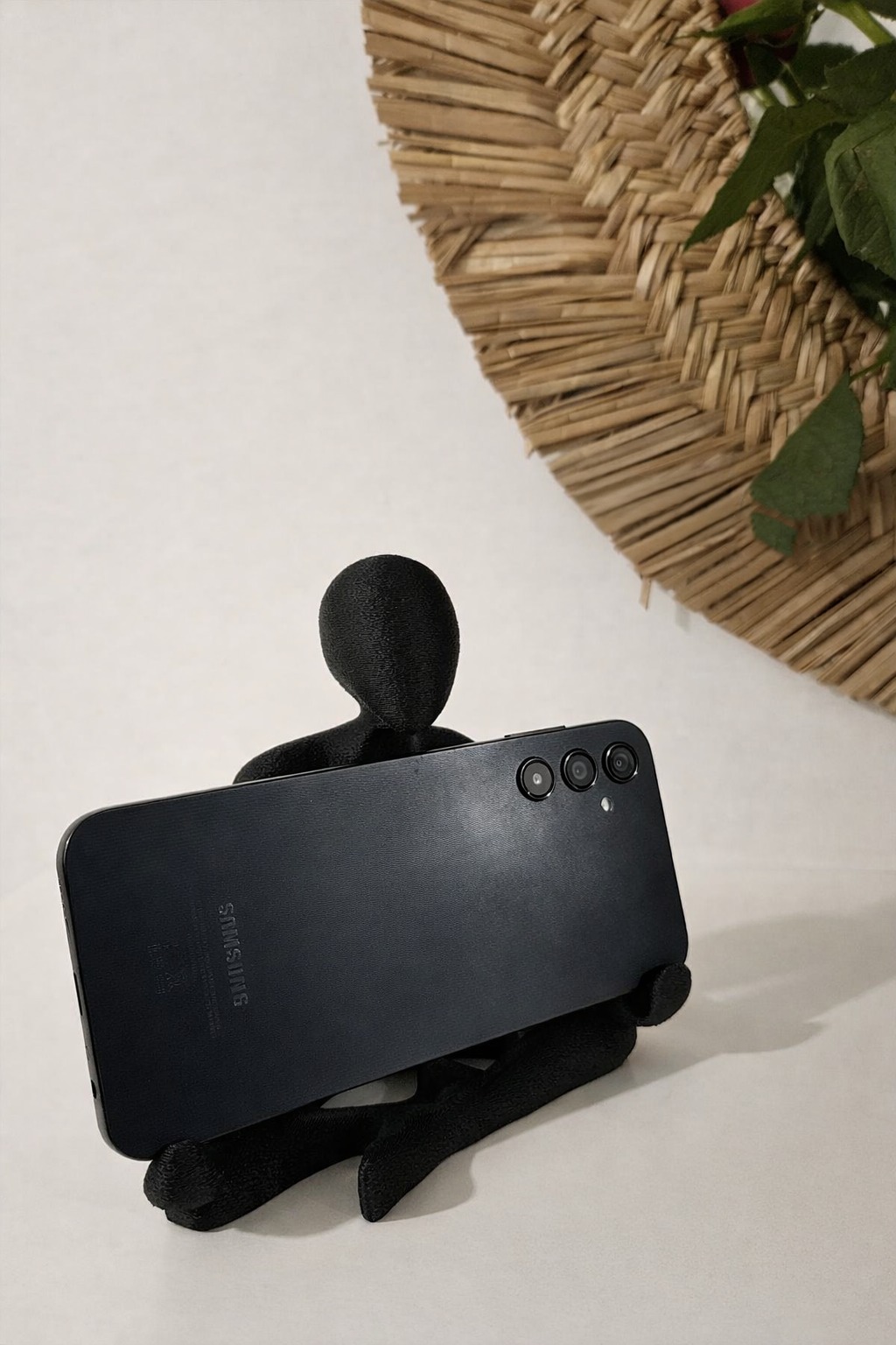 Black Nobody sculpture holding a phone in a customer home